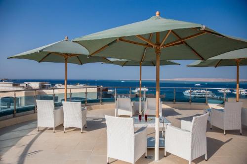 a patio with tables and chairs and umbrellas at Redcon Suites in Hurghada
