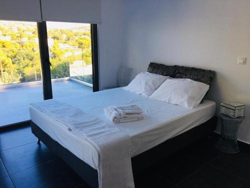 a bedroom with a bed with towels on it at Villa tranquility in Lagonissi