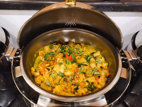 a pan filled with food on a stove at Halogen Hotel Merauke in Merauke