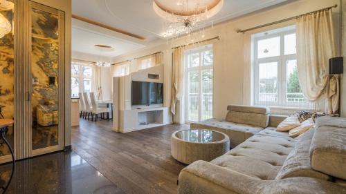 a living room with a couch and a table at Grand Lehe Beach Apartment in Pärnu