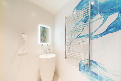 uma casa de banho com um lavatório e uma pintura na parede em Starboard Side Hotel em Moscou