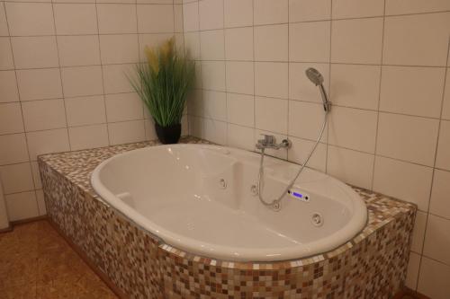 y baño con bañera y grifo. en Haus-Dorfidyll, en Spangenberg