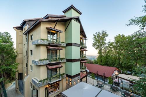 an apartment building with balconies and trees at Petit Palais Platres Boutique Hotel in Platres