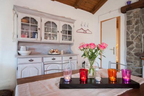 una cocina con una mesa con un jarrón de rosas rosas en Holiday Home Stella, en Zaton