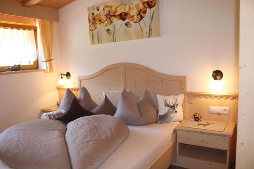 ein Schlafzimmer mit einem Bett mit Kissen darauf in der Unterkunft Untertalhof in Kastelruth