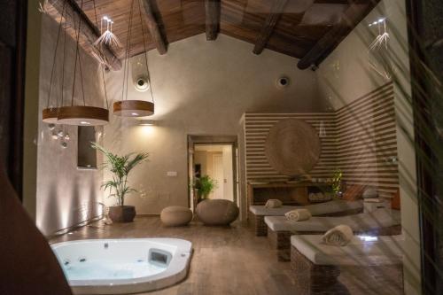 a large bathroom with a tub and a couch at Relais San Giuliano in Viagrande