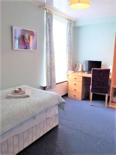 a bedroom with a bed and a desk and a window at Luther King House in Manchester