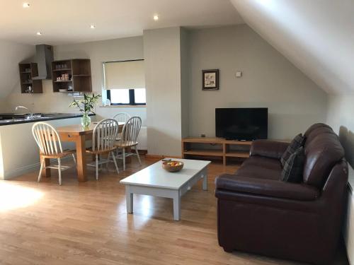 a living room with a couch and a table at Cael Uisce apartment 31 Cliff road in Belleek