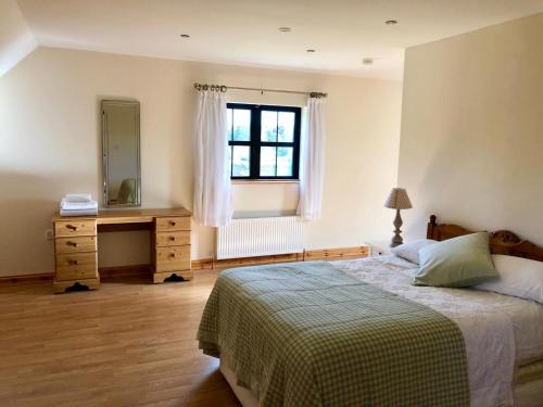 a bedroom with a bed and a dresser and a mirror at Cael Uisce apartment 31 Cliff road in Belleek