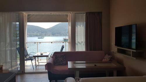 a living room with a couch and a view of the water at Ola Kala Apartments and Rooms in Vlikhon