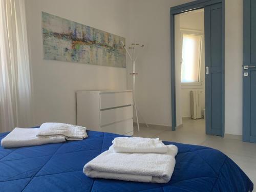 a blue bed with towels on top of it at Bona Ciurrata in Golfo Aranci