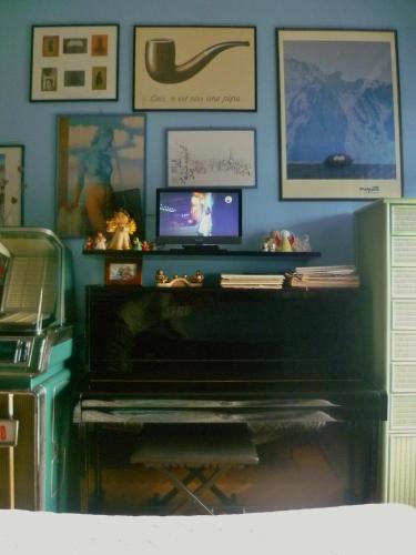 a living room with a piano and a wall with pictures at La Terrazza Sul Po in Turin