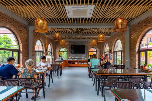 a dining room with people sitting at tables at Tam Coc Banana Bungalow in Ninh Binh