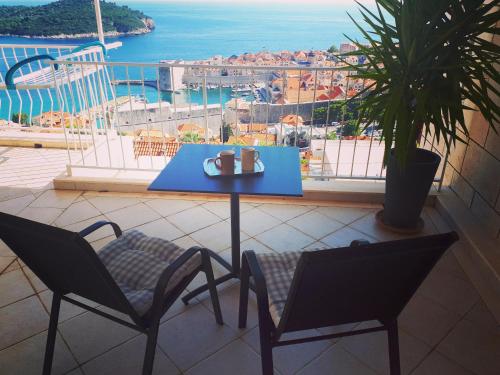 un tavolo e sedie blu su un balcone con vista di Studio Ogresta a Dubrovnik