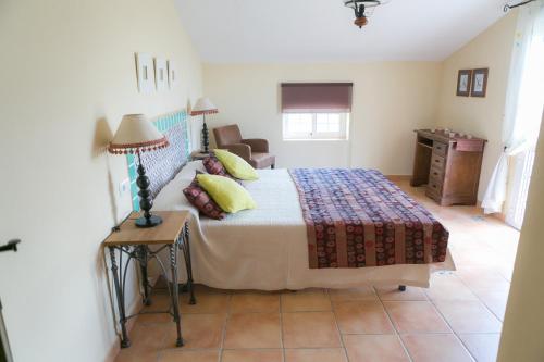 a bedroom with a bed and a table with a lamp at Casa Lo Pinto Private Pool Villa South of El Torcal in La Joya