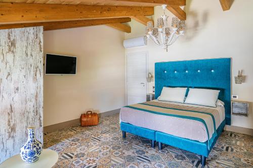 a bedroom with a bed with a blue headboard at DON GIULIO LUXURY ROOMS jacuzzi in Vico Equense