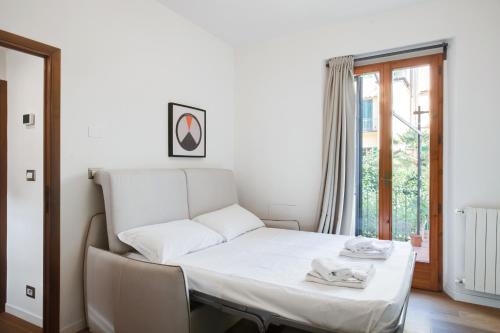 een wit bed in een kamer met een raam bij Santa Reparata Apartment with Patio and Terrace in Florence