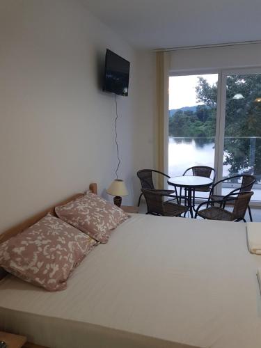 a bedroom with a bed and a table and a window at Apartman Nikolic in Veliko Gradište