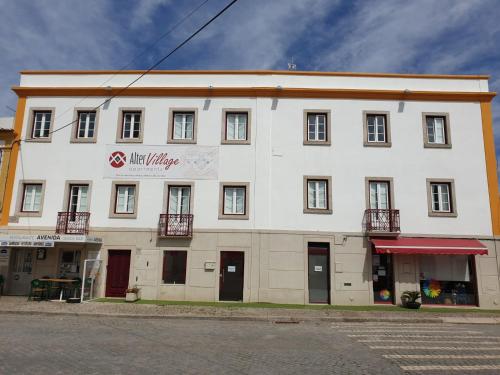 a large white building with a sign on it at Alter Village Apartments in Alter do Chão