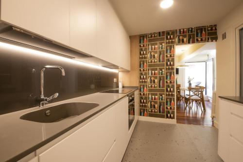 una cocina con fregadero y una pared de libros en Aletxo's Home, en San Sebastián