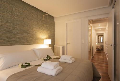 een slaapkamer met een bed met handdoeken erop bij Aletxo's Home in San Sebastian