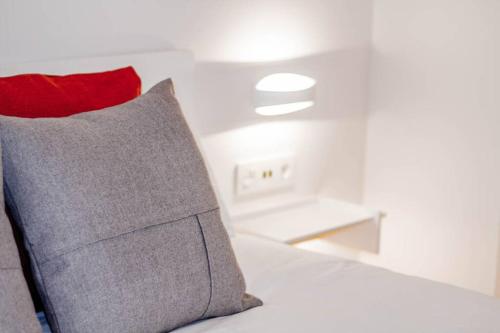 a bed with a red pillow in a room at ATSEDEN apartment aire condicionado - Opción a parking - in San Sebastián