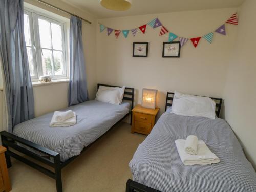 two beds in a room with flags on the wall at Driftwood in Filey