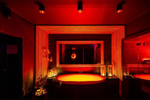 czerwona łazienka z dużą wanną z lustrem w obiekcie Spa Love Apartament Sauna Jacuzzi ROMANTYCZNY APARTAMENT DLA PARY Z PRYWATNYM SPA w Zielonej Górze
