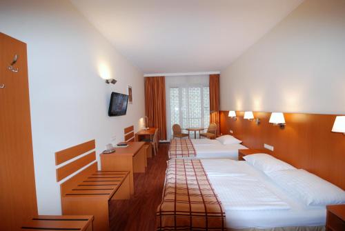 Habitación de hotel con 4 camas y escritorio. en Continental Hotel-Pension, en Viena