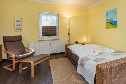 a hotel room with a bed and a chair at Ferienwohnungen Störtebeker in Zempin