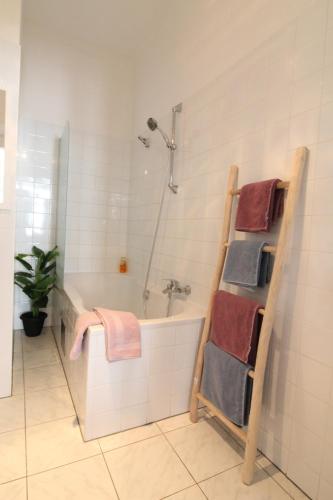 een badkamer met een douche, een bad en handdoeken bij Apartment Villa Penzing in Wenen