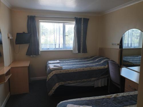 mały pokój z 2 łóżkami i oknem w obiekcie Elmhurst Hotel w mieście Reading