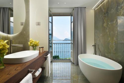 baño con 2 lavabos y ventana grande en Grand Hotel Victoria concept & spa, by R Collection Hotels en Menaggio