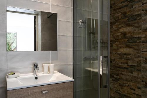 a bathroom with a sink and a glass shower at Hôtel Corniche du Liouquet in La Ciotat