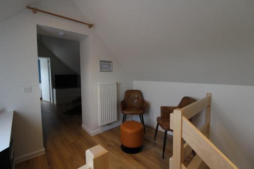 a living room with two chairs and a staircase at De Ast by De Oude Kaasmakerij in Passendale