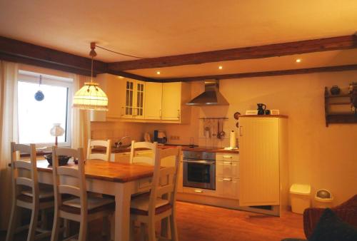 una cocina con mesa de madera y una cocina con armarios amarillos en Landhaus Loipe, en Leutasch