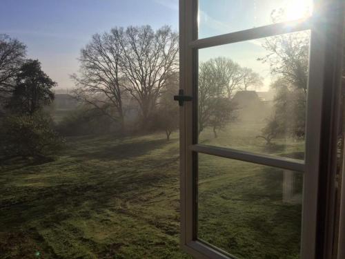 a window with a view of a field outside at Pfarrhof Stuer in Stuer