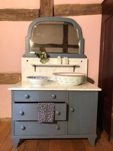 a blue dresser with a mirror and two bowls on it at Pfarrhof Stuer in Stuer