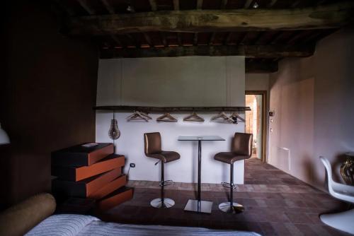 a bedroom with two stools and a table with shoes at Morelliana4Rooms in Scansano