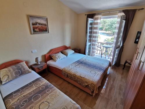 a bedroom with two beds and a balcony at Apartments Abramovic in Sutomore