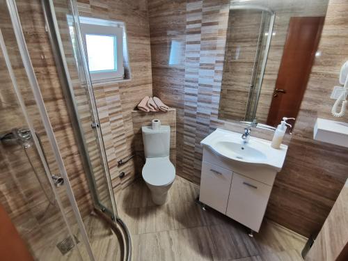 a bathroom with a toilet and a sink and a shower at Apartments Abramovic in Sutomore