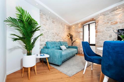 un soggiorno con divano blu e una pianta di Apartments Casa De Amicis a Rovigno (Rovinj)