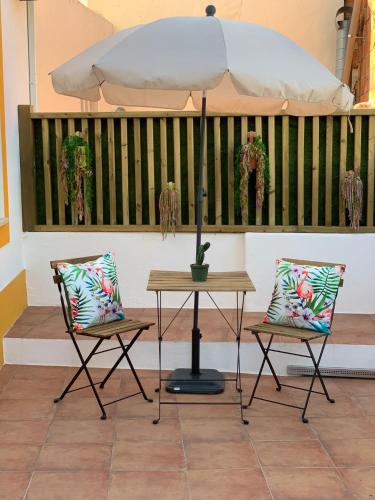 a table and two chairs with an umbrella at Alter Village Apartments in Alter do Chão