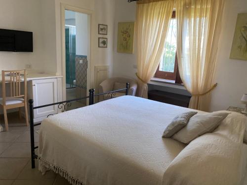 a bedroom with a white bed and a window at B&B Il Vicolo in Anacapri