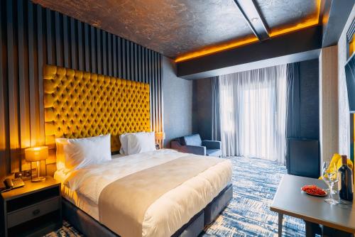 a hotel room with a large bed and a desk at Tapis Rouge Design Boutique Hotel in Batumi
