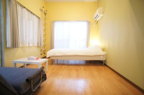 a small room with two beds and a window at Plusone Nishikoen in Fukuoka