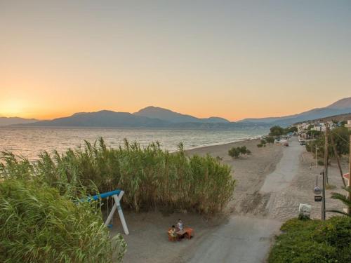 a person sitting on the beach near the water at Aristodimos Luxury Suite in Kalamaki Heraklion