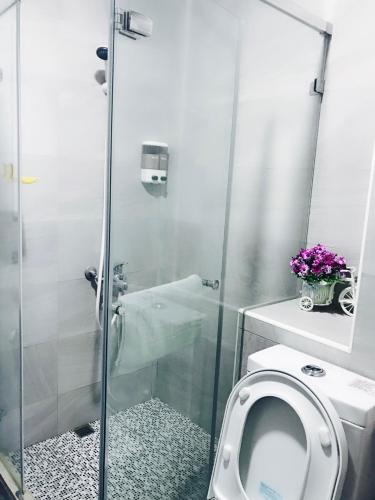 a bathroom with a toilet and a glass shower at Aliya阿利亞 in Huwei