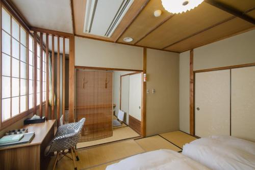 um quarto com uma cama e uma secretária com uma cadeira em Kaigetsu em Toba