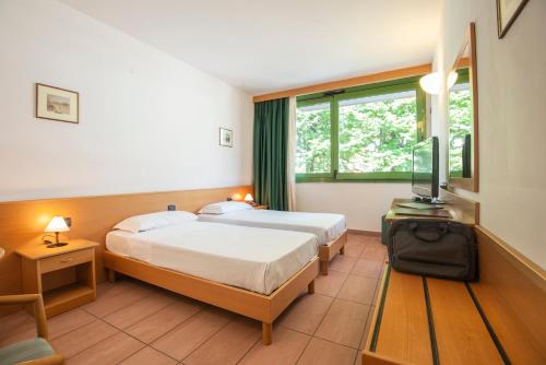 een hotelkamer met 2 bedden en een raam bij Park Hotel Abbadia in Abbadia Lariana